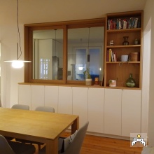 Ventanal corredero con estantería y armarios, nexo de unión entre cocina y salón